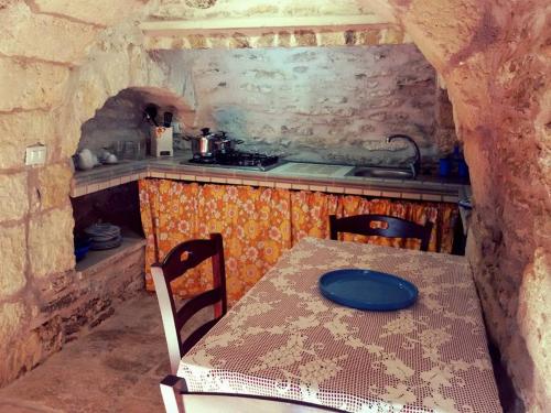 フランカヴィッラ・フォンターナにあるTrullallàのキッチン(テーブル、青い皿付)