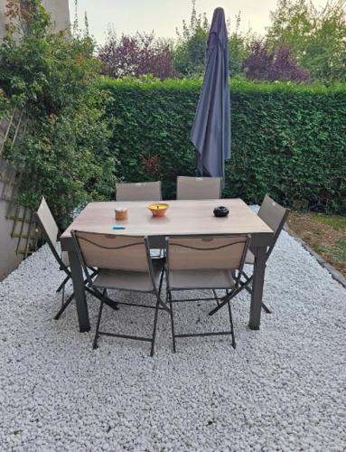 - une table et des chaises avec un parasol sur une terrasse en gravier dans l'établissement Joli logement spacieux, à Annecy