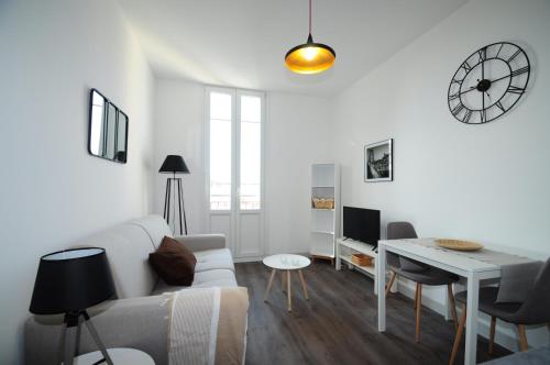 un salon blanc avec un canapé blanc et une table dans l'établissement Les Trois Mai, à Cannes