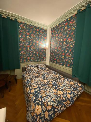 une chambre avec un lit avec un papier peint fleuri dans l'établissement L'imprimerie A2, studio cosy au coeur de la Roche !, à La Roche-sur-Yon