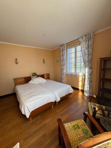 une chambre avec un grand lit et une fenêtre dans l'établissement Auberge des Ruines de Merle, à Saint-Cirgues-la-Loutre