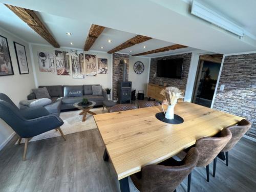 a living room with a wooden table and chairs at Haus Bergstadtblick Fewo Auszeit in Sankt Andreasberg