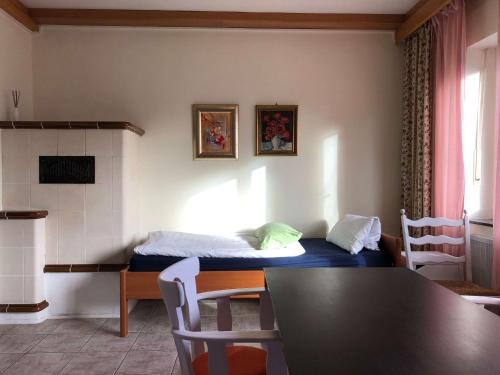 a room with a bed and a table and chairs at Apartment in Gelb, mit Balkon, Kamin, 50 Schritte zu Radweg, ideal for Long Stay, 4 Singles in Single Rooms in Mainstockheim