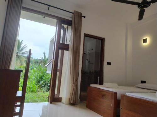 a bedroom with a large window and a bed and a mirror at Kandy Lotus Chalet in Kandy