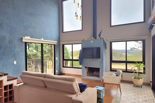 a living room with a couch and a fireplace at Casa, Pequeno Bosque e vista para Horizonte in Ibiúna