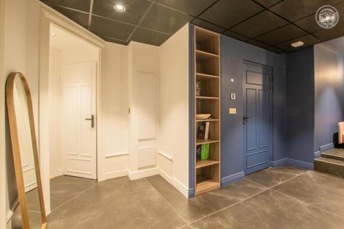 a room with blue walls and a door and shelves at Astoria hausmannien in Aix-les-Bains
