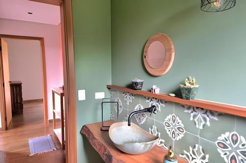 a bathroom with a sink and a mirror at Casa, Pequeno Bosque e vista para Horizonte in Ibiúna