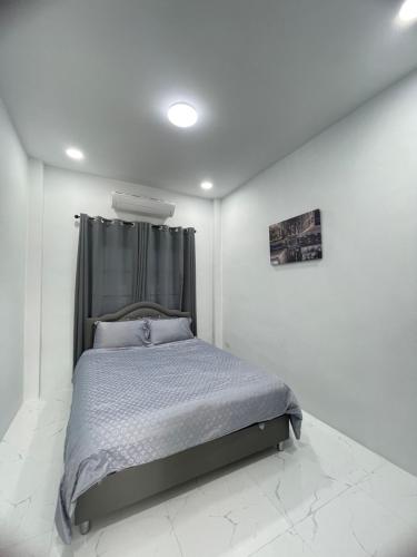 a bedroom with a bed in a white room at บ้านพักขอนแก่น in Ban Nong Waeng
