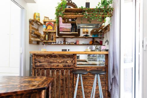 a kitchen with a wooden counter and stools at Relax a 4 salti dai navigli in Milan