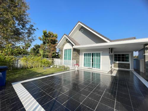 a house with a tile driveway in front of a house at บ้านพักขอนแก่น in Ban Nong Waeng