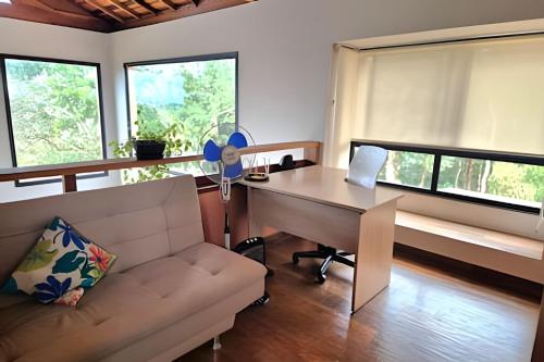 a living room with a desk and a couch at Casa, Pequeno Bosque e vista para Horizonte in Ibiúna