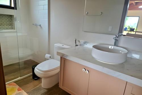 a bathroom with a white sink and a toilet at Casa, Pequeno Bosque e vista para Horizonte in Ibiúna