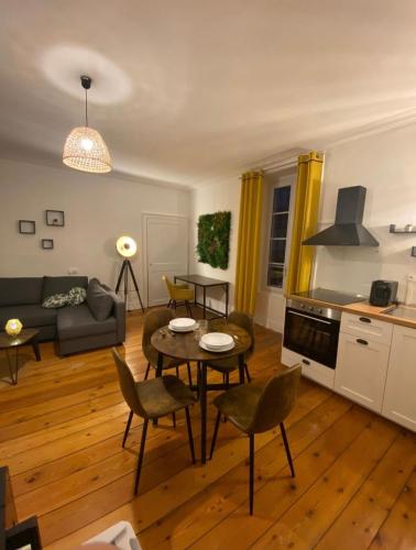un salon avec une table et des chaises dans l'établissement L'Imprimerie B1, studio cosy au coeur de La Roche, à La Roche-sur-Yon