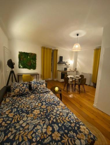 une chambre avec un lit et une salle à manger dans l'établissement L'Imprimerie B1, studio cosy au coeur de La Roche, à La Roche-sur-Yon