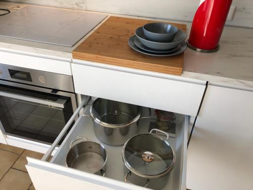 a kitchen with two pots and pans in a drawer at Apartment in Gelb, mit Balkon, Kamin, 50 Schritte zu Radweg, ideal for Long Stay, 4 Singles in Single Rooms in Mainstockheim