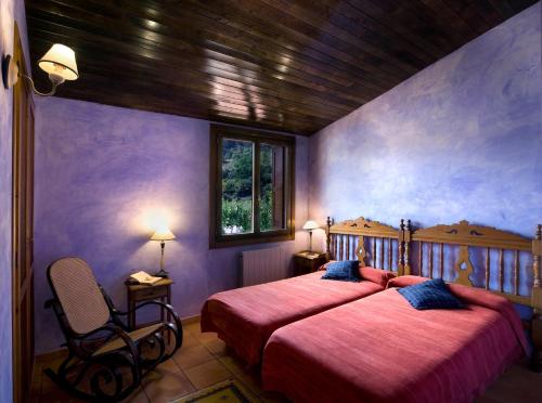 1 dormitorio con 2 camas en una habitación con paredes moradas en La Posada de San Millán, en San Millán de la Cogolla