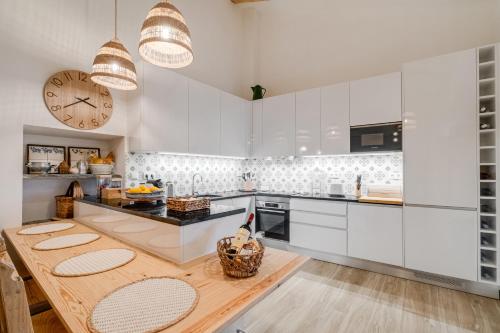 a kitchen with white cabinets and a wooden table at Monte Santo António - Alqueva in Mourão