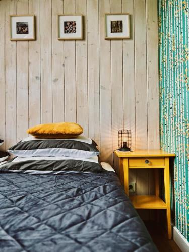 a bedroom with a bed and a wooden wall at Zagroda na Pacanach in Iwkowa