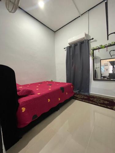 a room with a red bed and a mirror at Merang Jetty Homestay in Baroh Pahlawan