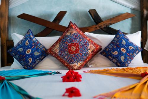 a group of colorful pillows on a bed at Casa Paradis Boutique Hotel in Jambiani