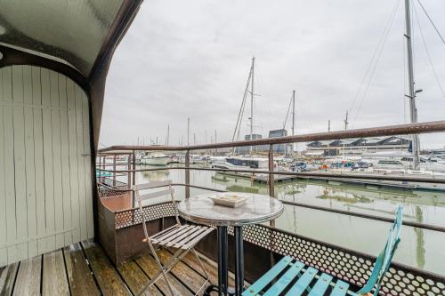 a table and chairs on a balcony with a marina at Superbe Péniche En Centre Ville in Bordeaux