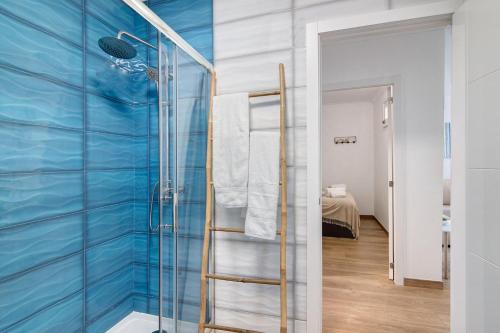 a bathroom with a glass shower with blue walls at Seaside Heaven - Praia da Rocha in Portimão