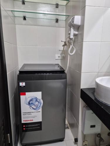 a trash can in a bathroom with a phone at 1BR Cozy Condo at Kasara Urban Resort Pasig City in Manila