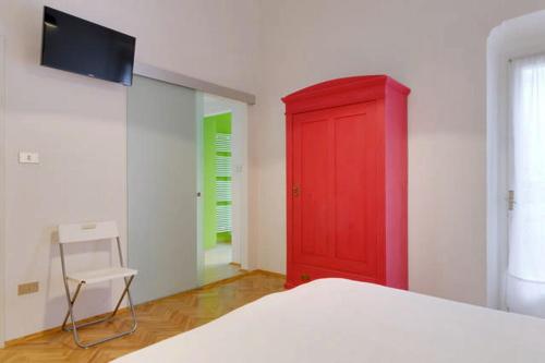 a bedroom with a red cabinet and a chair at Al Cavour 34 in Trento