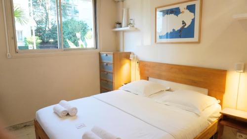 une chambre avec un lit avec deux serviettes dessus dans l'établissement Proche Croisette, Studio Cosy by Palmazur, à Cannes