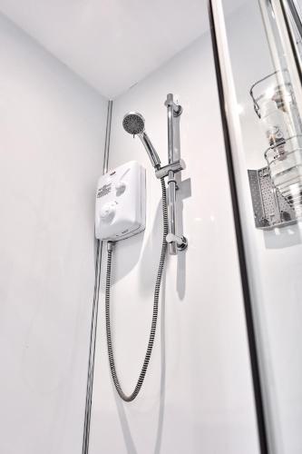 a shower in a bathroom with a shower head at Stylish apartment close to Causeway Coast & Glens in Portglenone