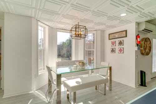a dining room with a glass table and a chandelier at Fall Escape on Lookout Shoals Lake with Game Room! in Sharon