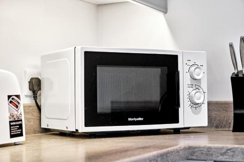 a microwave oven sitting on top of a counter at Stylish apartment close to Causeway Coast & Glens in Portglenone