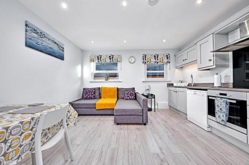 a living room with a couch and a kitchen at Stylish apartment close to Causeway Coast & Glens in Portglenone