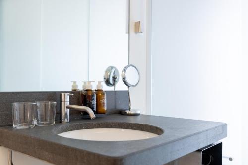 a bathroom counter with a sink and a mirror at Greulich Design & Boutique Hotel in Zürich