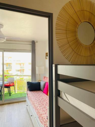 une chambre avec un lit avec un miroir et une fenêtre dans l'établissement Joli studio les pieds dans l'eau avec piscine, à Saint Cyprien Plage
