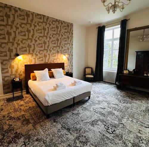 a bedroom with a large bed and a large window at Logis Hôtels Château de La Barge in Chaintré