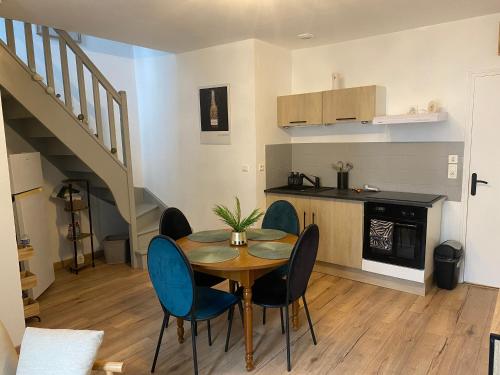 une salle à manger avec une table et des chaises et une cuisine dans l'établissement Le 12 Epernay, à Épernay
