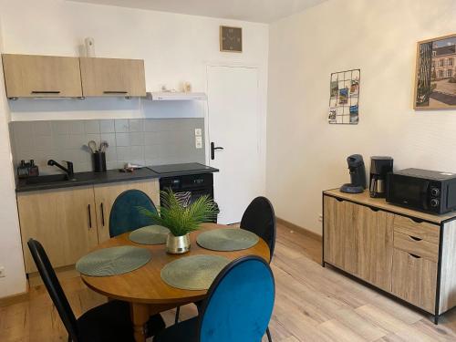 une cuisine avec une table et des chaises dans une pièce dans l'établissement Le 12 Epernay, à Épernay