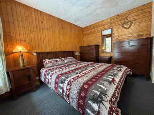- une chambre avec un lit et des murs en bois dans l'établissement Large Duplex Apartment 8 persons, à Plagne 1800
