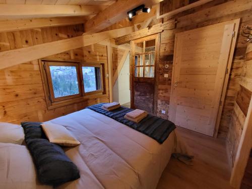 a bedroom in a log cabin with a large bed at Chalet La Telier in Montriond
