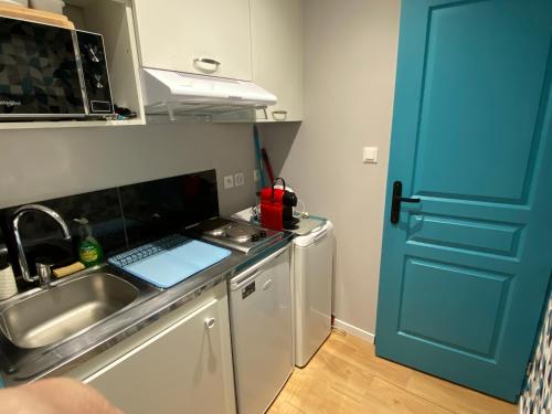 a kitchen with a sink and a blue door at Les Apparts de la Tourronde in Chorges