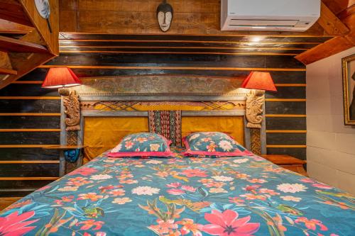 a bedroom with a bed with a blue comforter and two lamps at Superbe Péniche En Centre Ville in Bordeaux