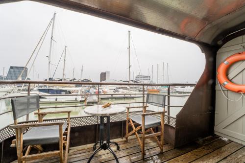 a table and chairs on the deck of a boat at Superbe Péniche En Centre Ville in Bordeaux