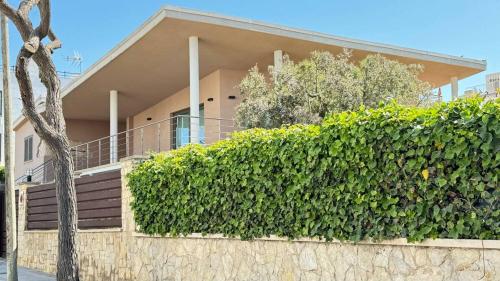 a house with a hedge in front of a building at Best Leisure in Playa de Palma in Can Pastilla