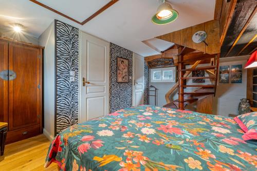 a bedroom with a bed with a floral bedspread at Superbe Péniche En Centre Ville in Bordeaux