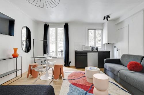 un salon avec un canapé et une table dans l'établissement CMG Résidence Bastille - Saint Antoine, à Paris