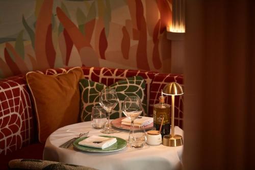 a table with wine glasses and a lamp on it at The Berkeley, Maybourne in London