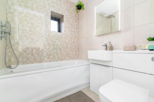 a white bathroom with a tub and a sink at Shoreditch Hoxton London City 3 bed 2 bath over 3 floors Suit Large Families in London
