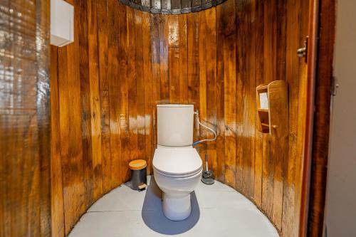 a bathroom with a toilet in a wooden wall at Superbe Péniche En Centre Ville in Bordeaux