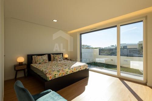 een slaapkamer met een bed en een groot raam bij Casa Mango by ACasaDasCasas in Ericeira